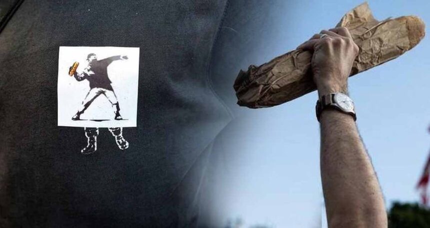 Direnişin yeni sembolü: Banksy’nin “Çiçek Fırlatan Adam”ı “Sandviç Adam”a dönüştü! Protesto gösterilerinde artık sandviç tutuyorlar